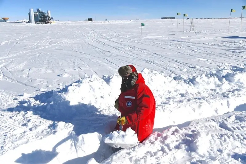 UD physicist Frank Schroeder shovels a trench for cables leading to a radio antenna he deployed at the South Pole.